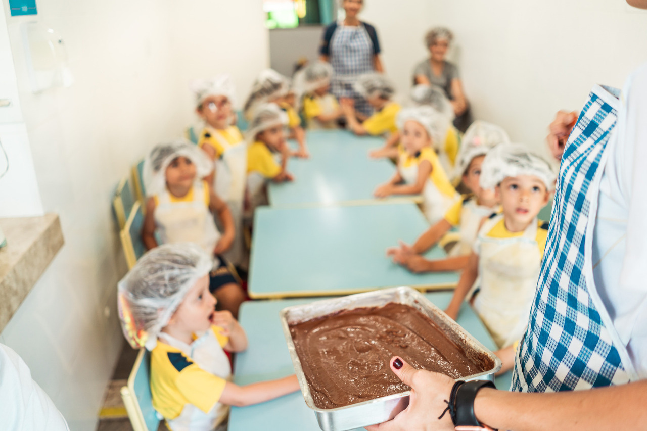 Crianças participam de uma atividade de culinária na escola